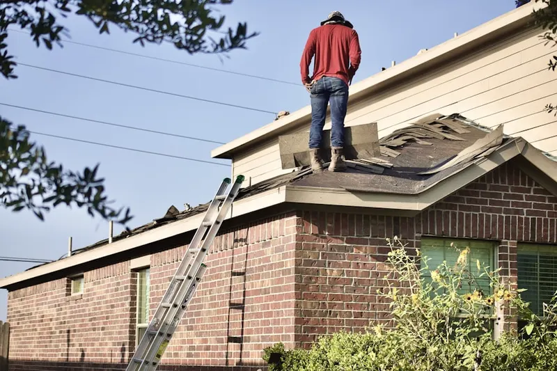 Professional roofer working on a residential roof in Quaker City